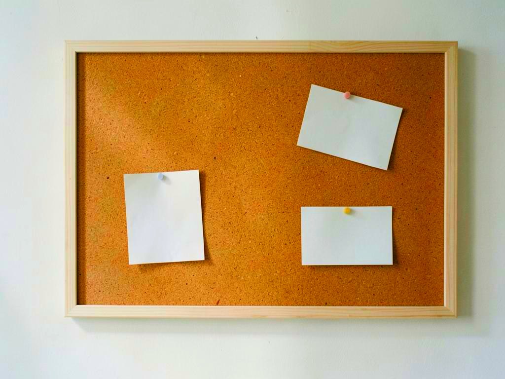 A noticeboard with pinned paper notes
